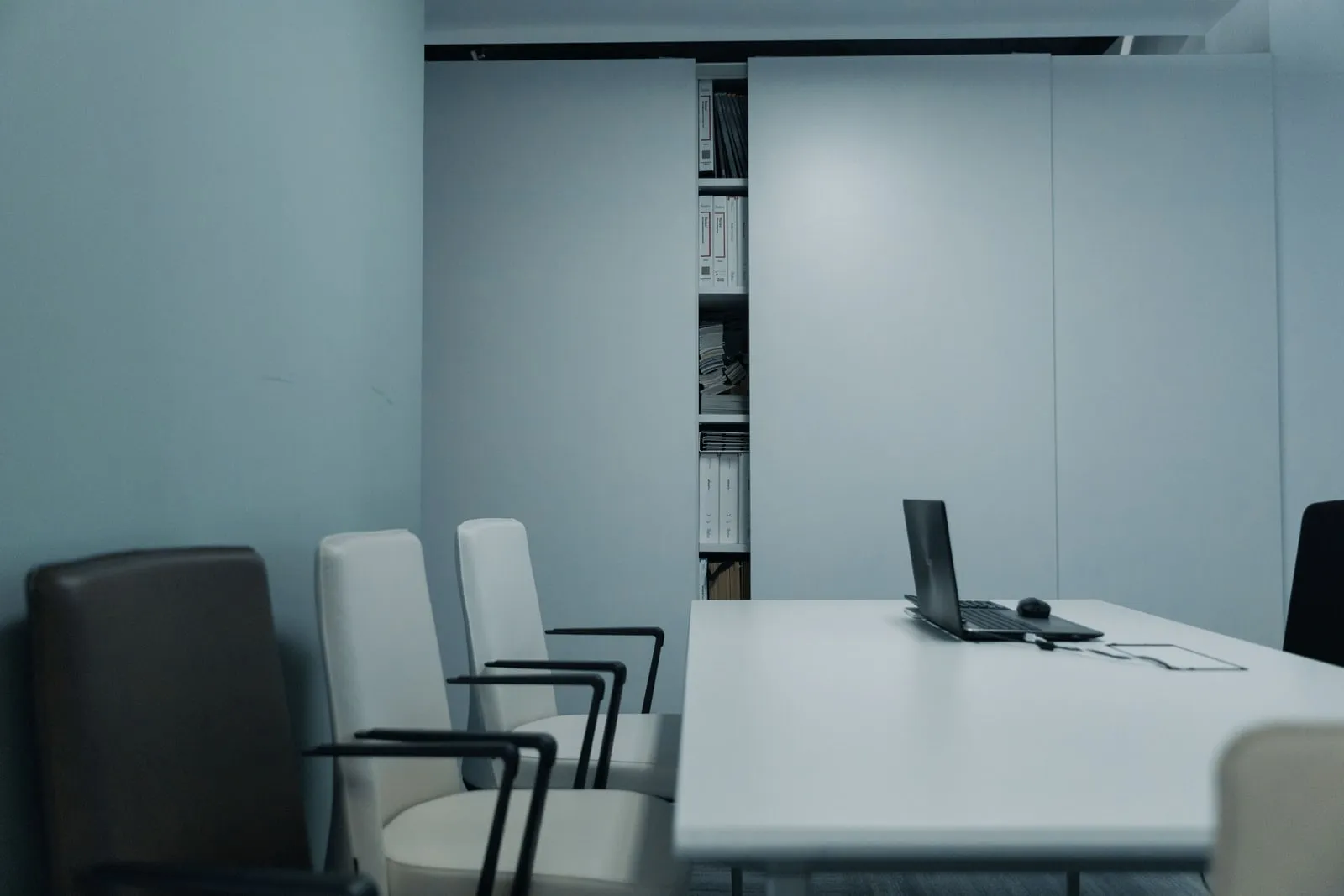 An empty conference table surrounded by office chairs