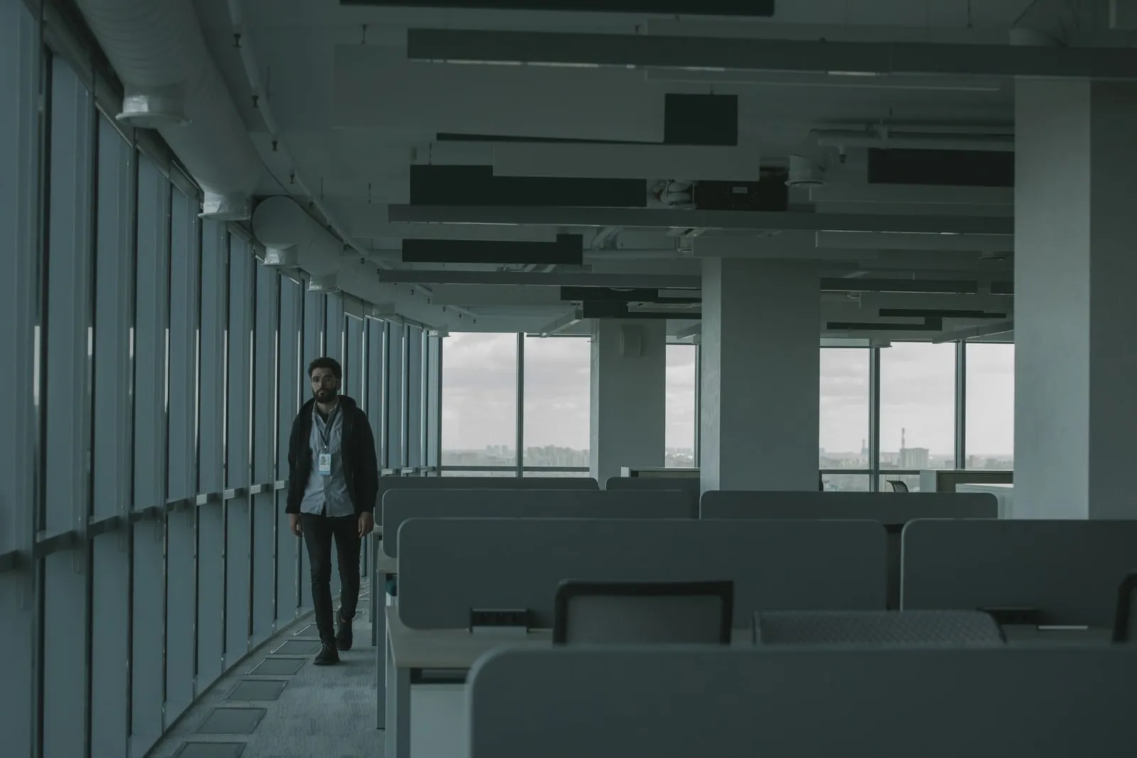 A person walking through a glass office corridor