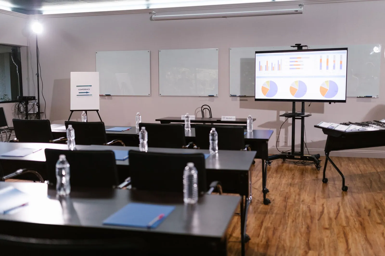 An empty meeting room with a projector screen and chairs