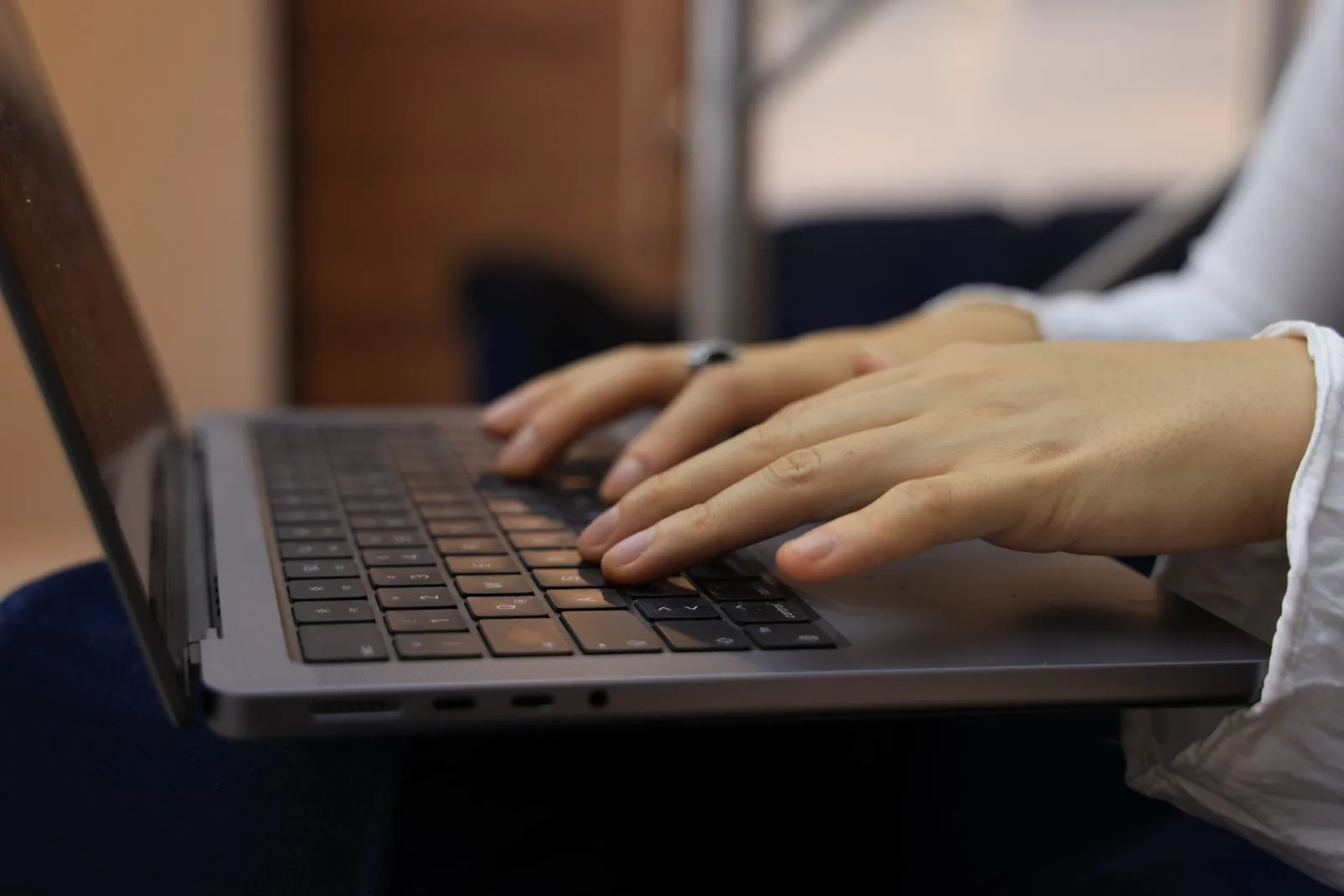 Hands typing on a laptop keyboard, seen close up