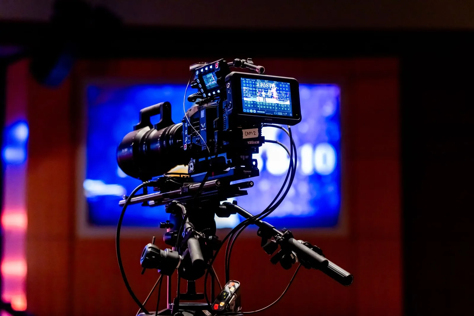 A professional film camera on a tripod in a studio