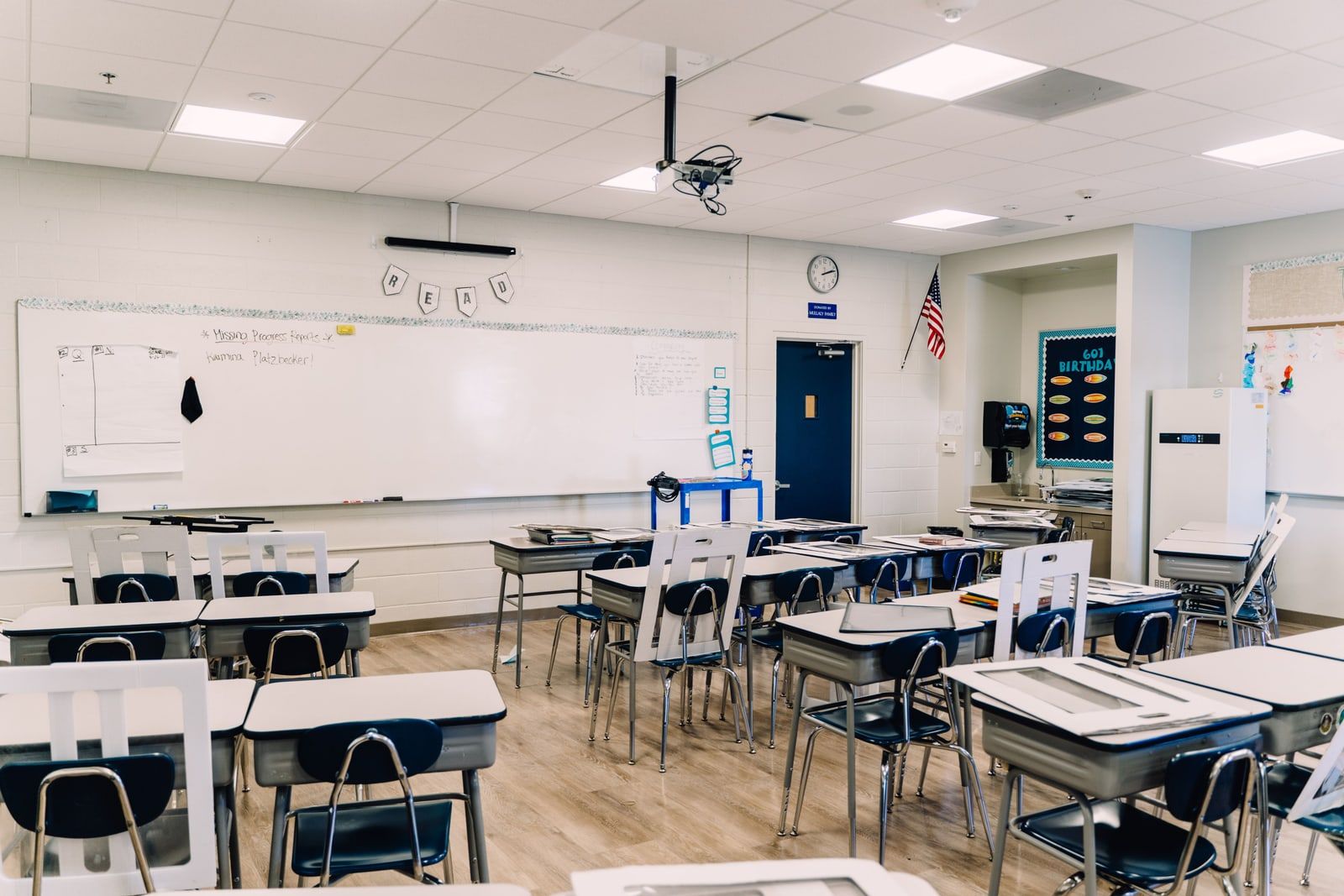 An empty classroom with rows of desks and chairs