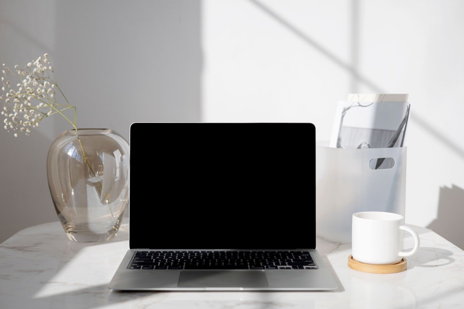 An open laptop on a white table in daylight