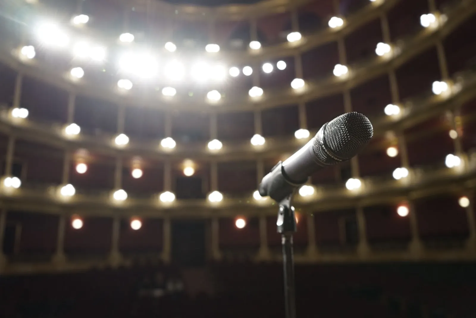 A microphone on a stand facing an empty theatre auditorium