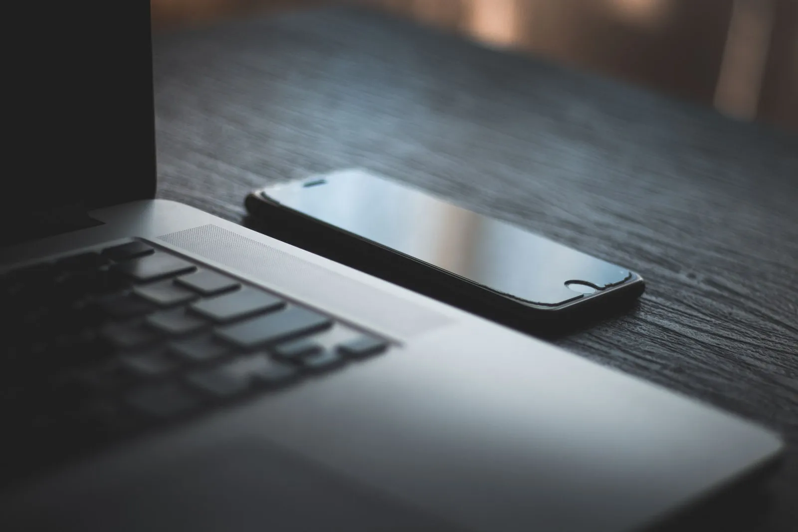 A smartphone lying beside an open laptop
