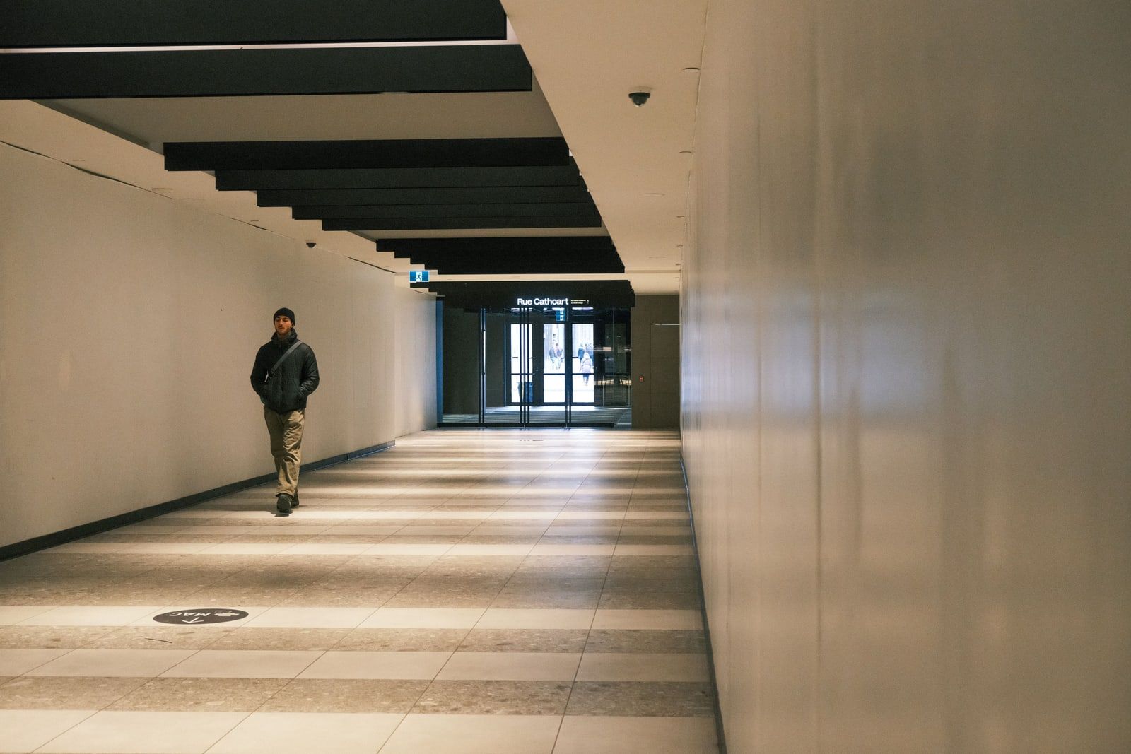 A person walking alone down a long corridor