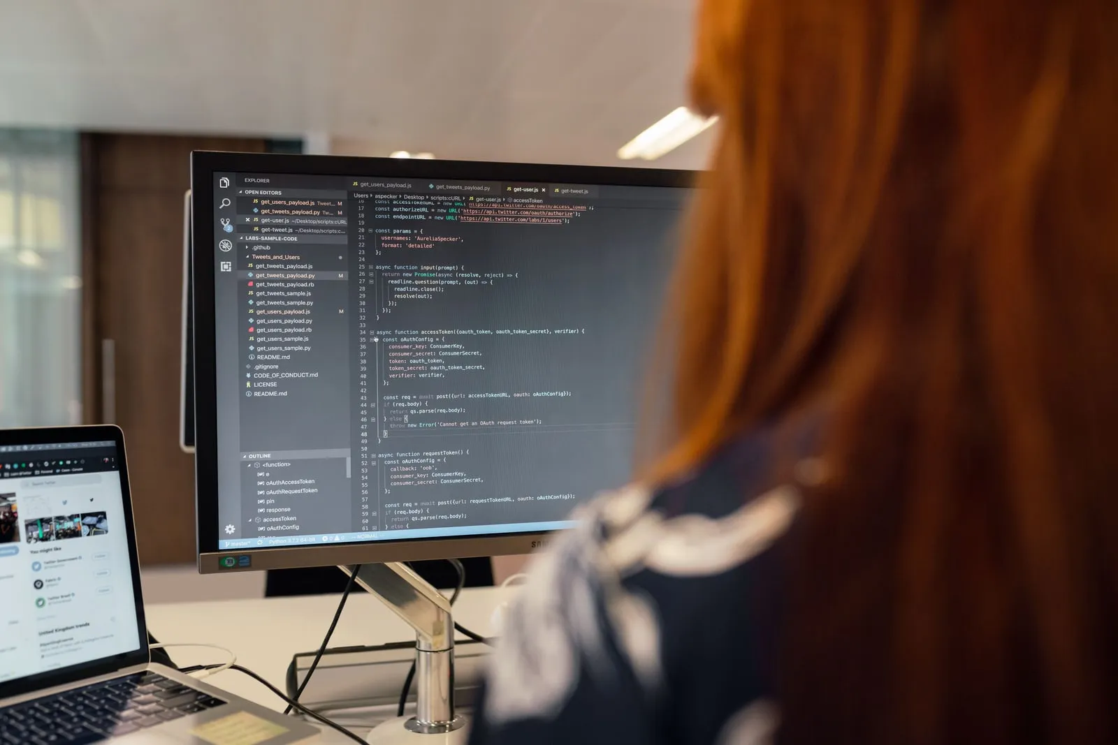 An engineer reviewing code on a large monitor