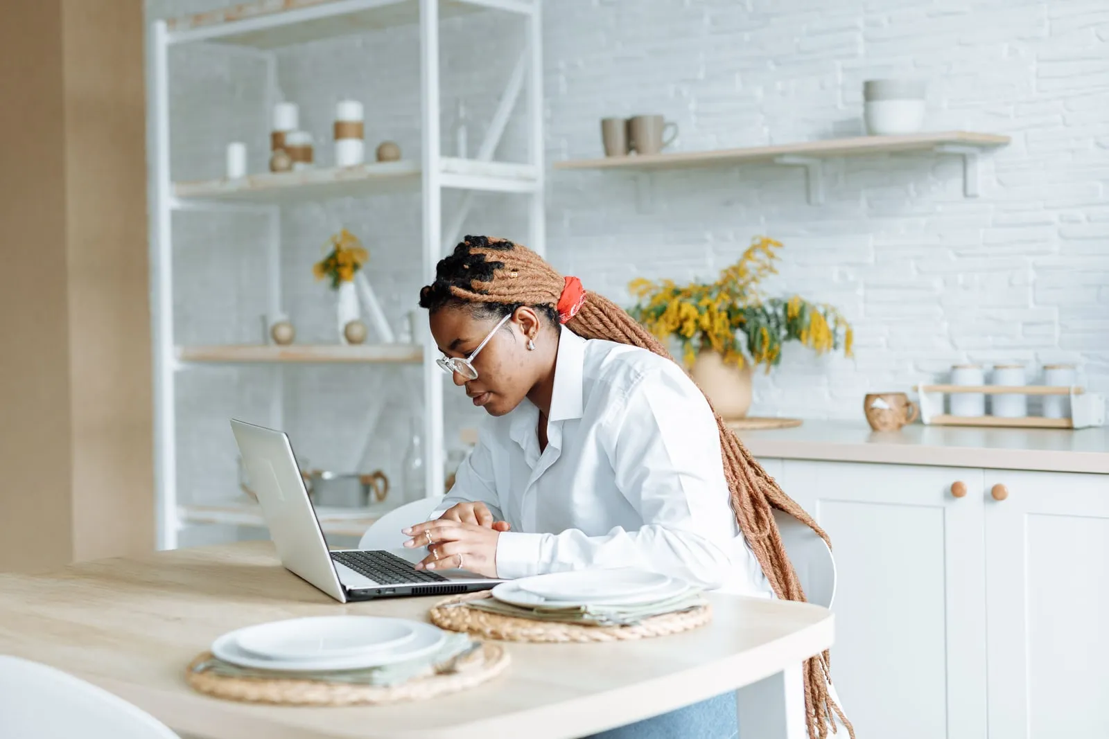 A person using a laptop at a kitchen table
