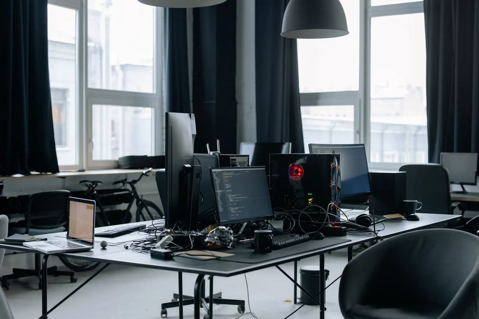 A developer's desk with several monitors in a daylit office