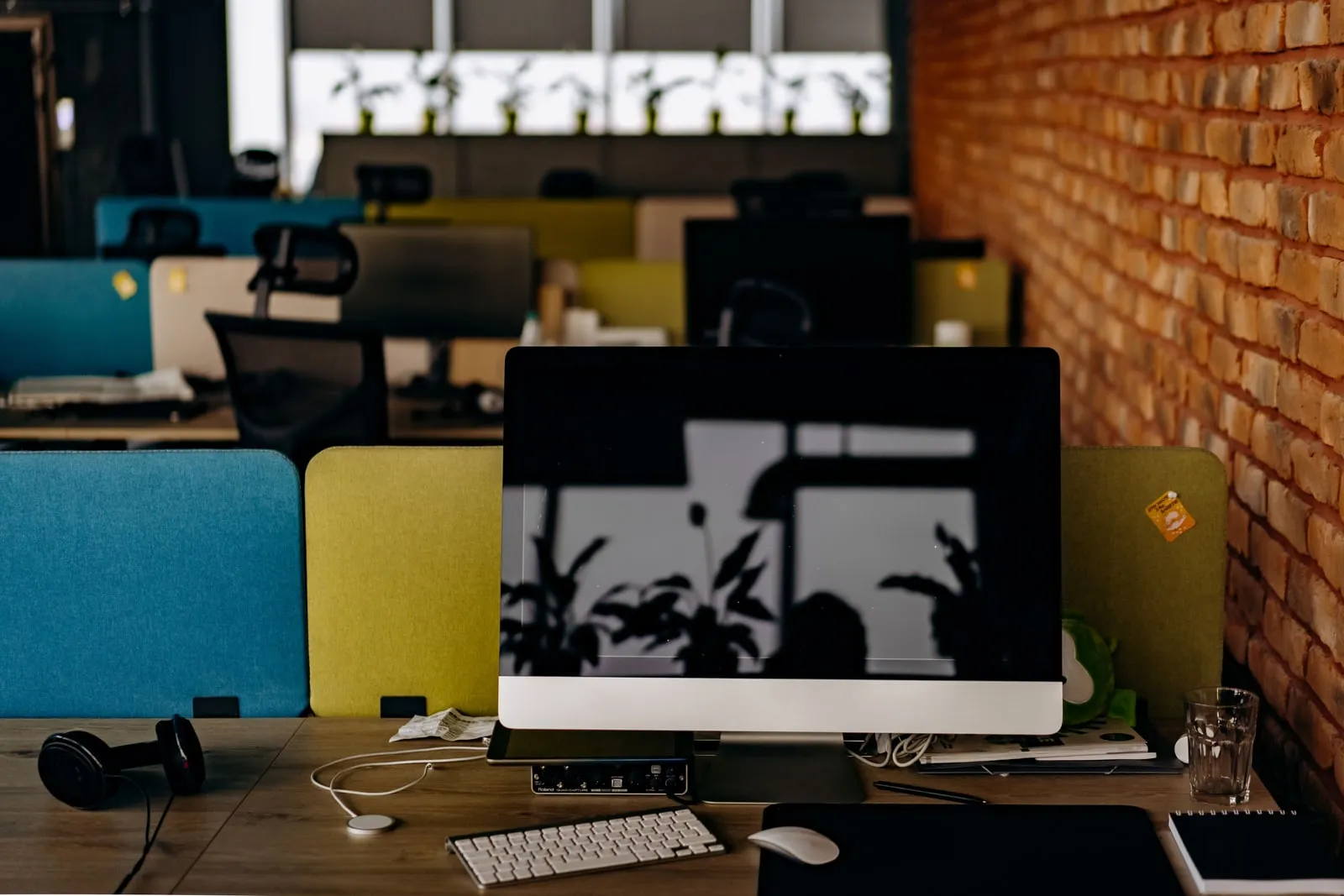 An empty desk with a monitor in an open-plan office