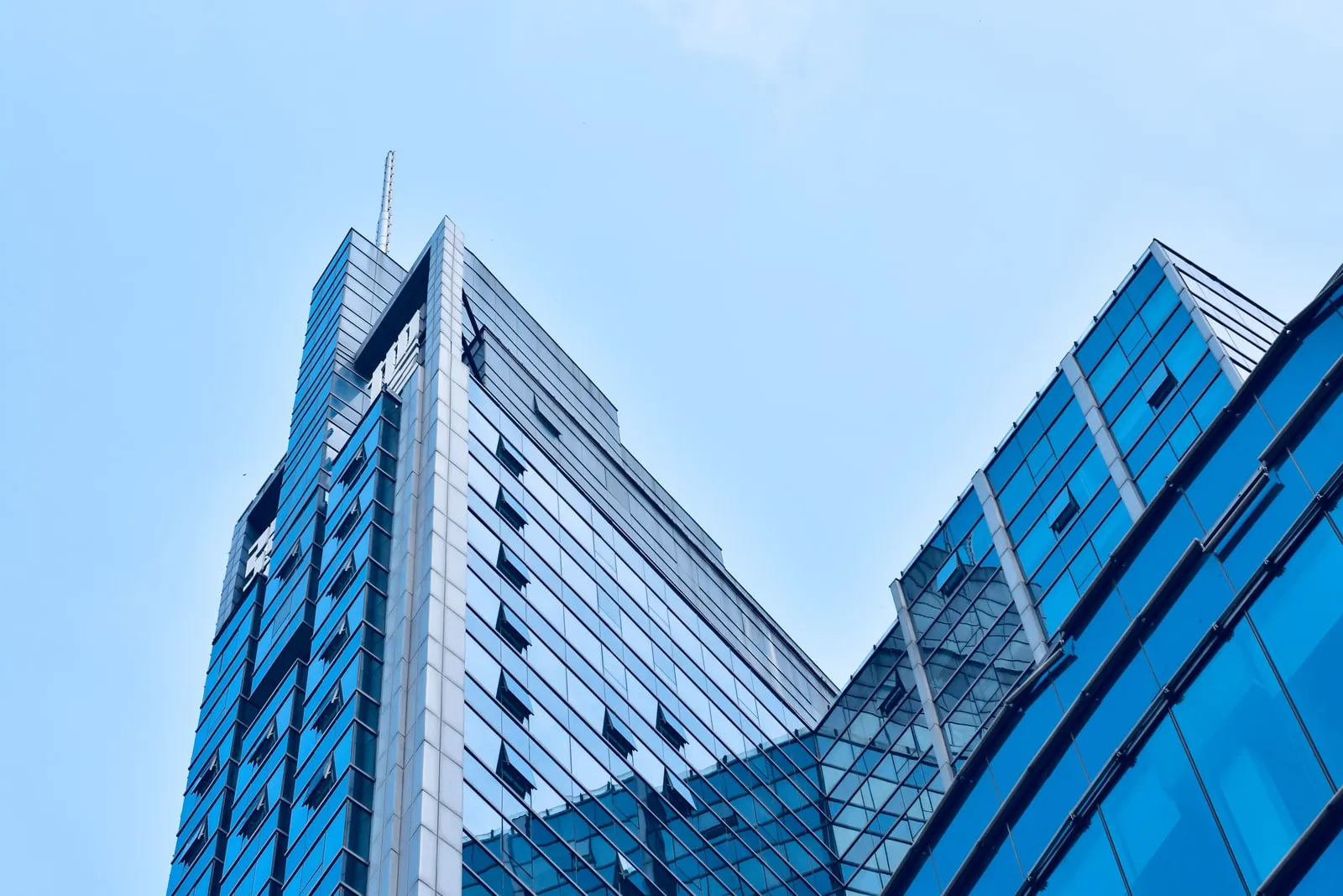 A glass office tower facade reflecting the sky