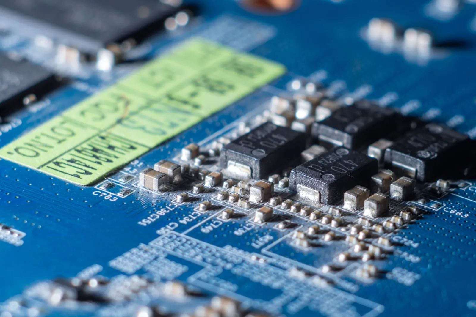 A close-up of small electronic components on a blue circuit board