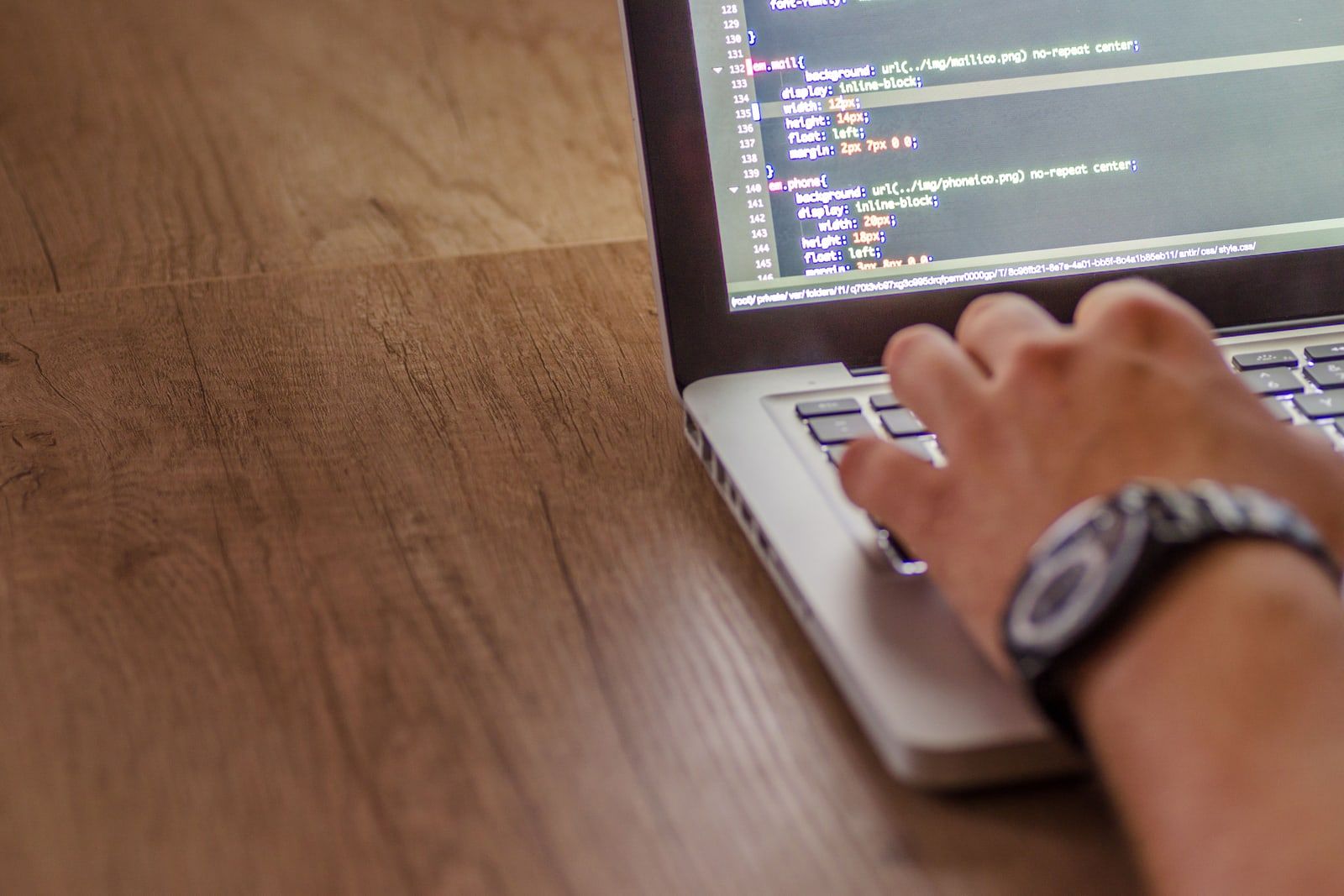A programmer writing code on a laptop at night