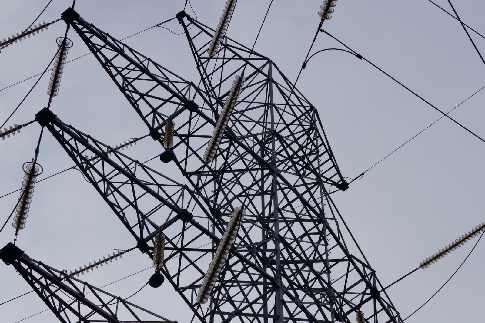 High voltage transmission pylons against a grey sky
