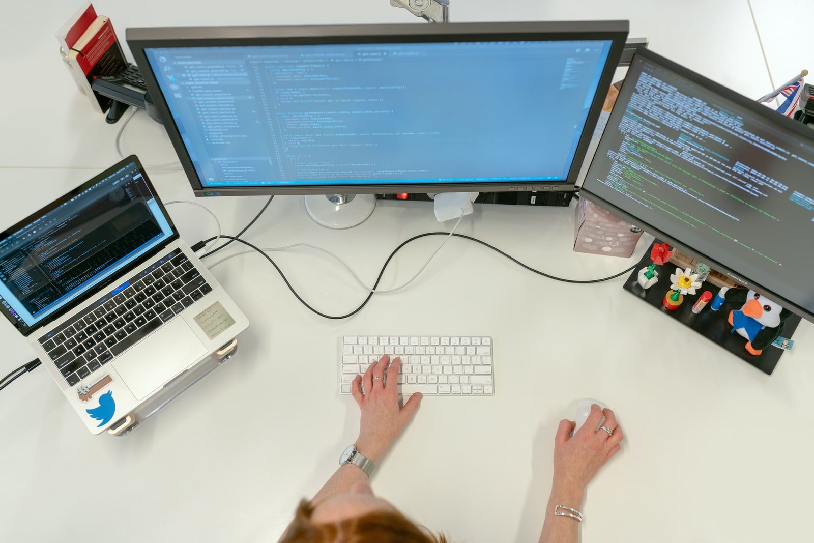 A person at a desk with several code editors open on screen