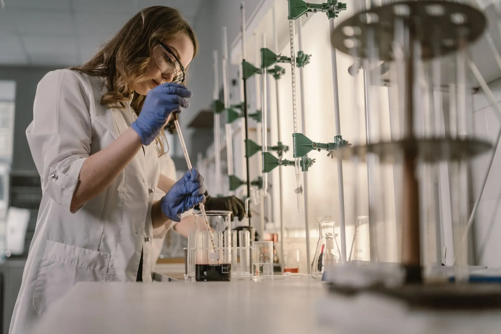 A scientist in a lab coat working at a laboratory bench