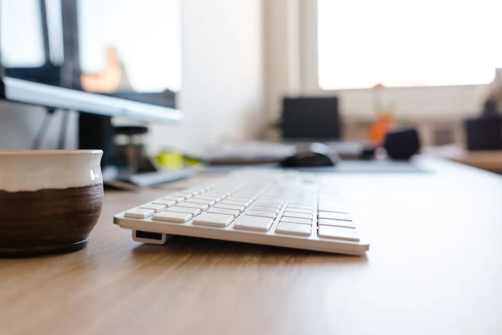 A computer keyboard on a desk in daylight