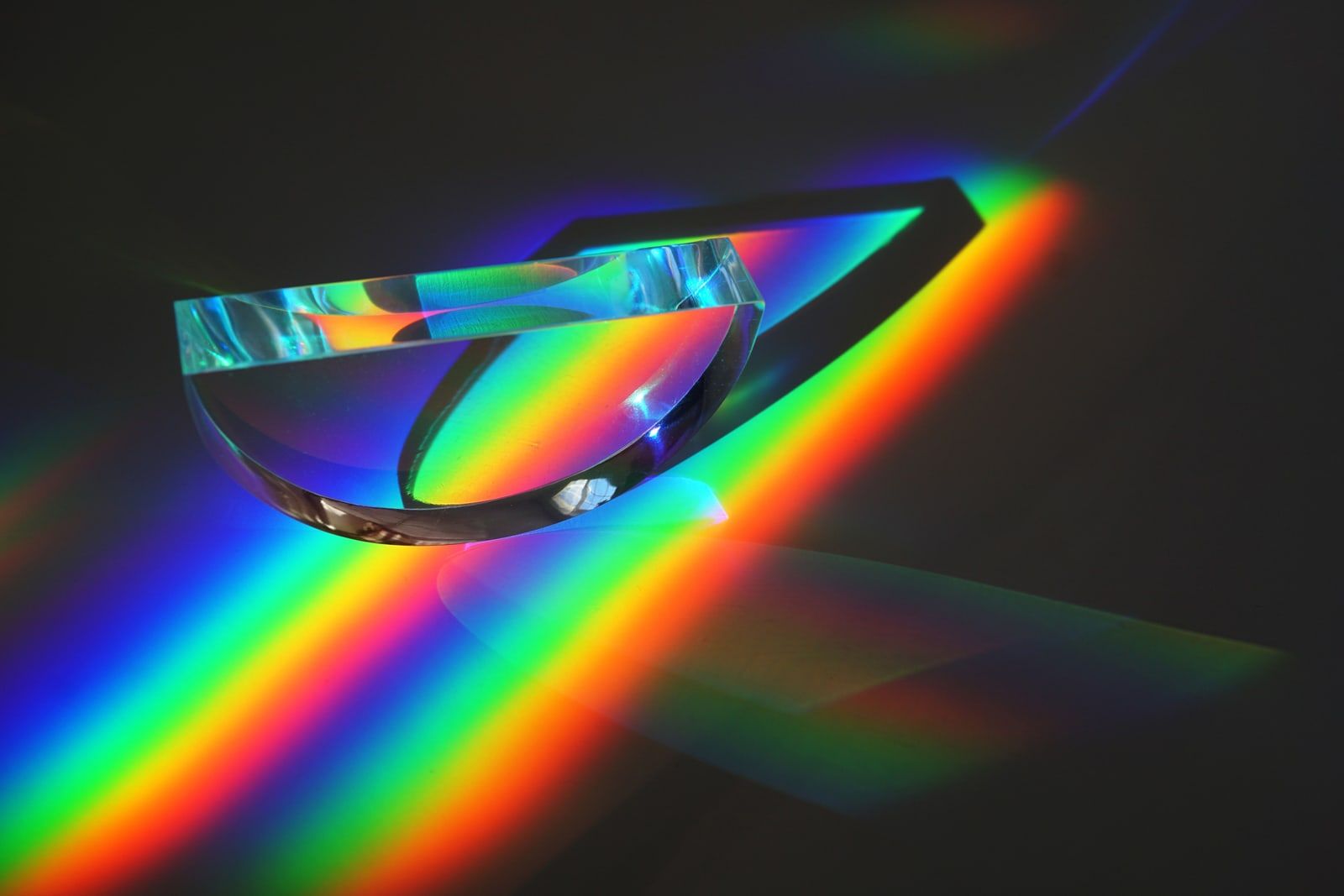 Glass prisms and lenses arranged on a dark surface
