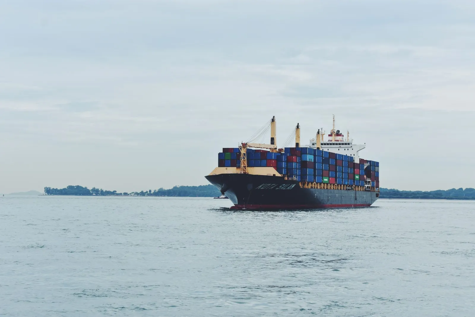 A cargo vessel loaded with containers under way at sea