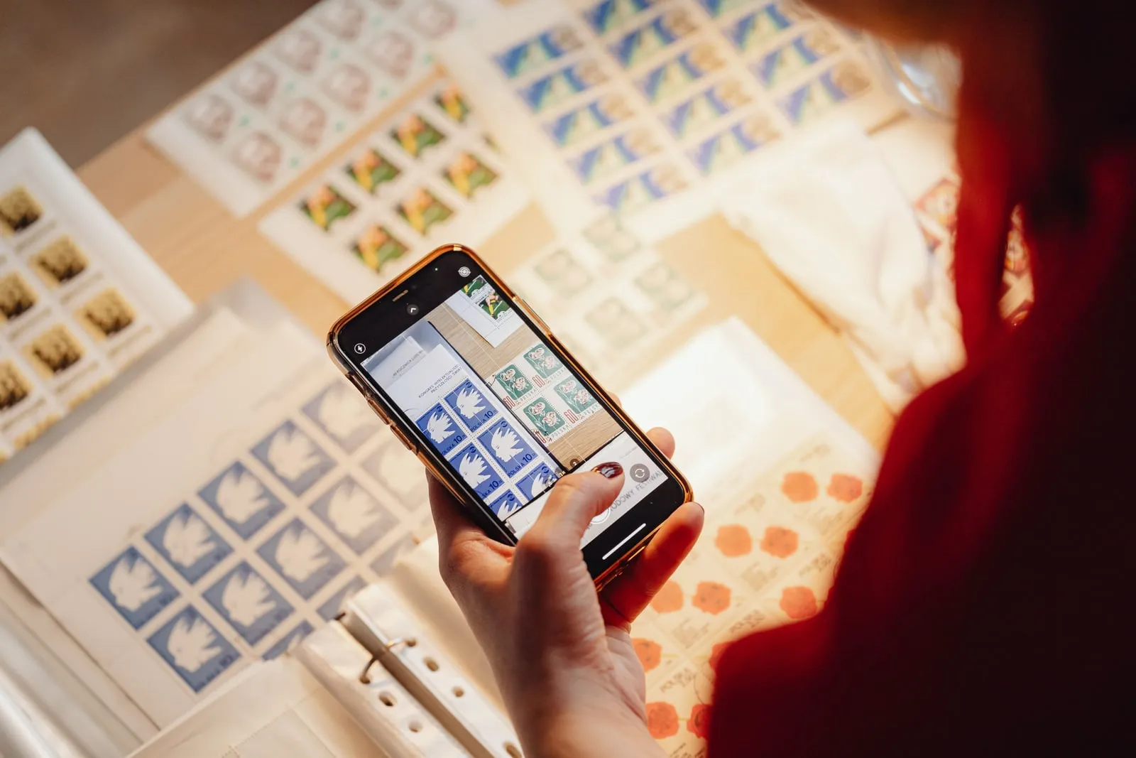 A person photographing printed sheets with a smartphone