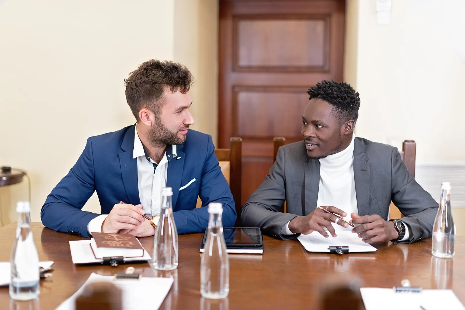 Two people talking across a meeting room table