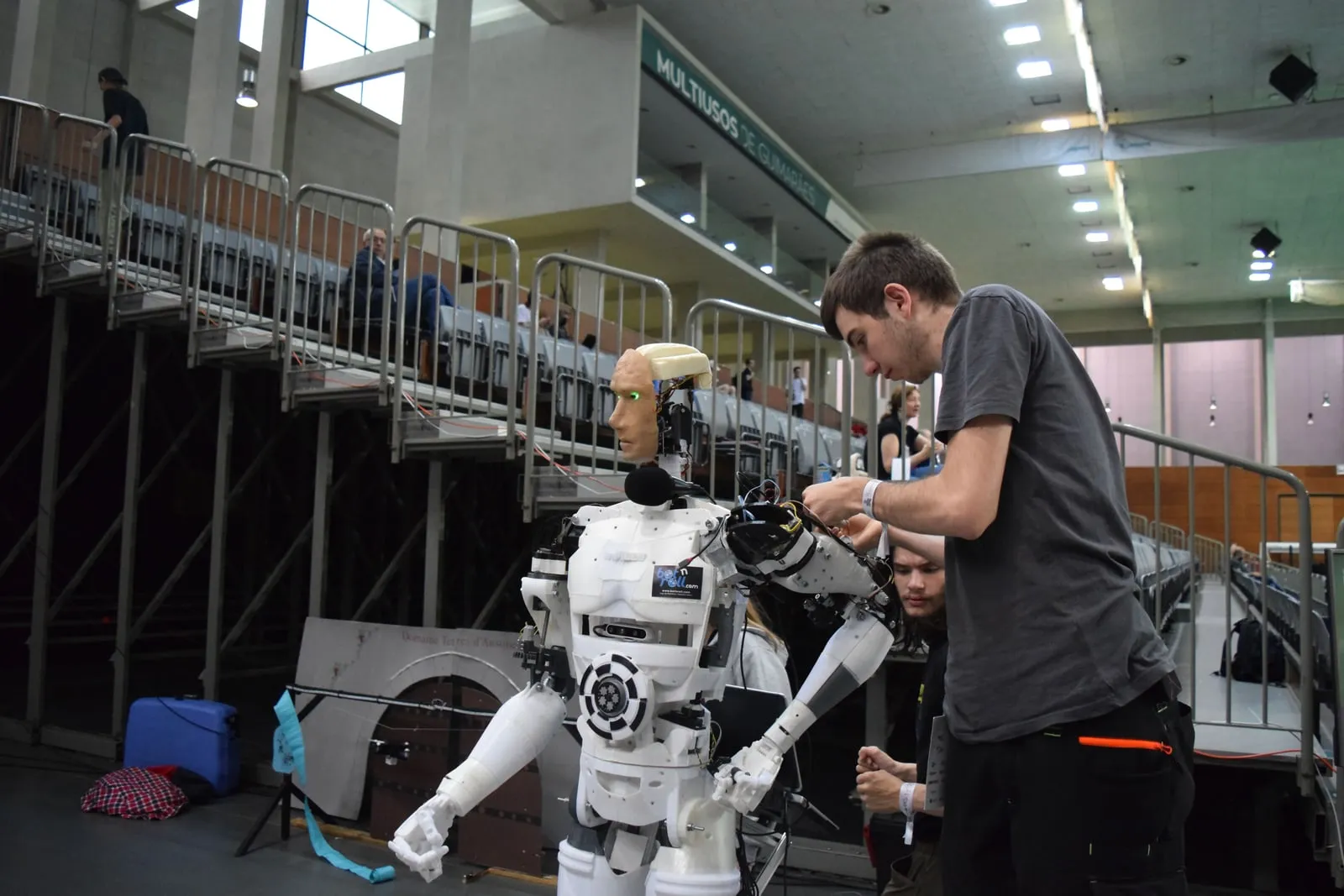 An engineer working on a robot arm in a workshop