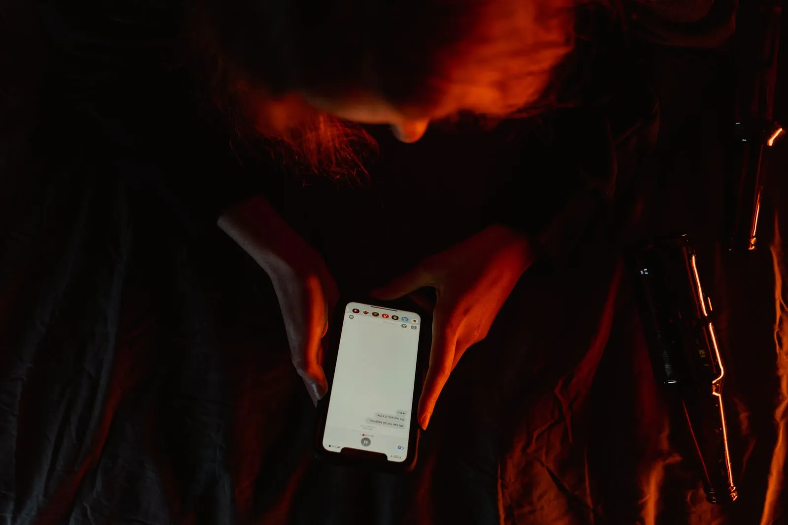 A person holding a phone in a dim living room