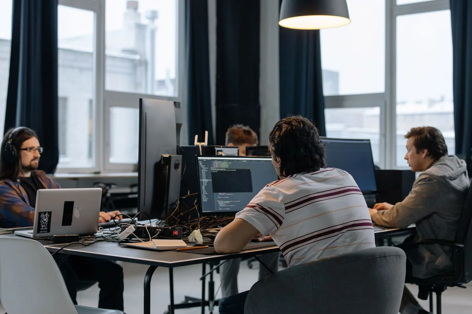 Two developers working side by side at computer screens in an office