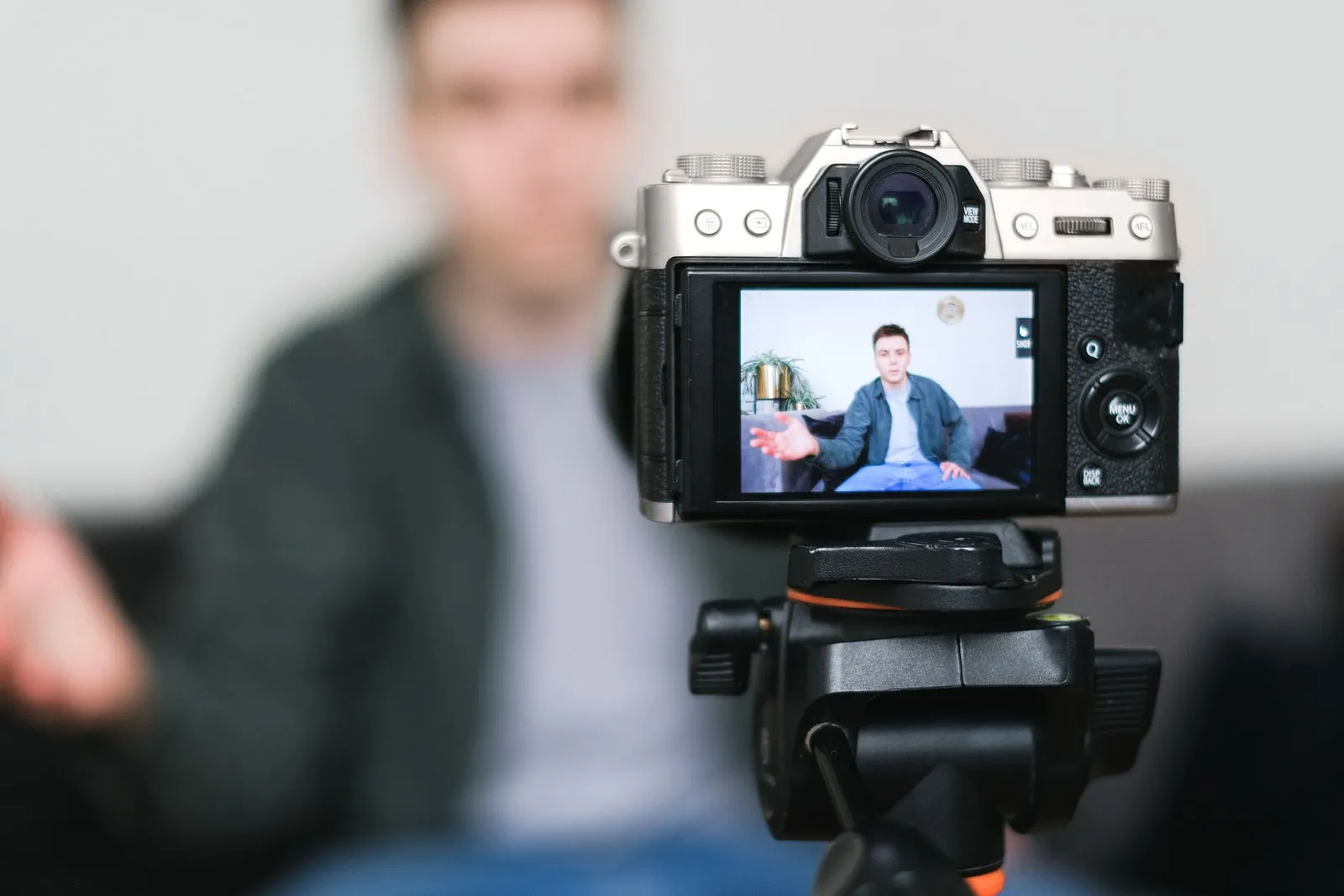 Un créateur de vidéo filme avec une caméra sur trépied dans un studio installé à domicile