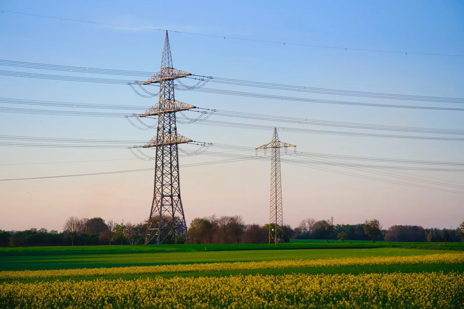 High-voltage transmission pylons carrying power lines across open country