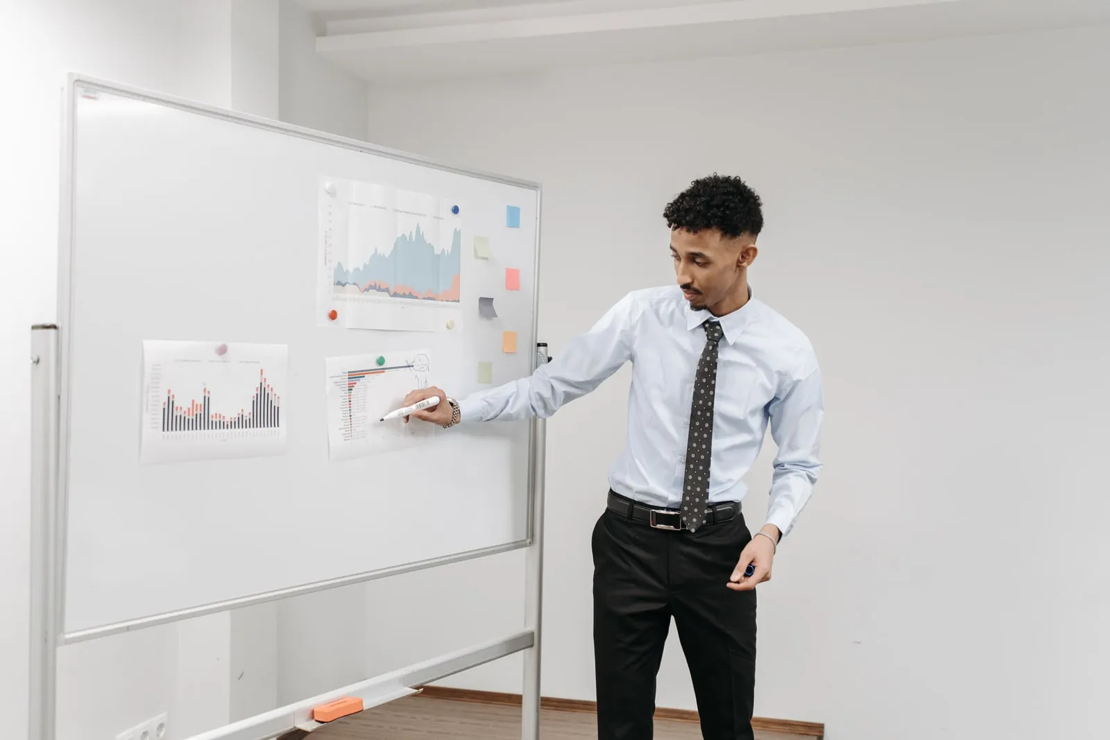 An economist writing on a whiteboard in a meeting room