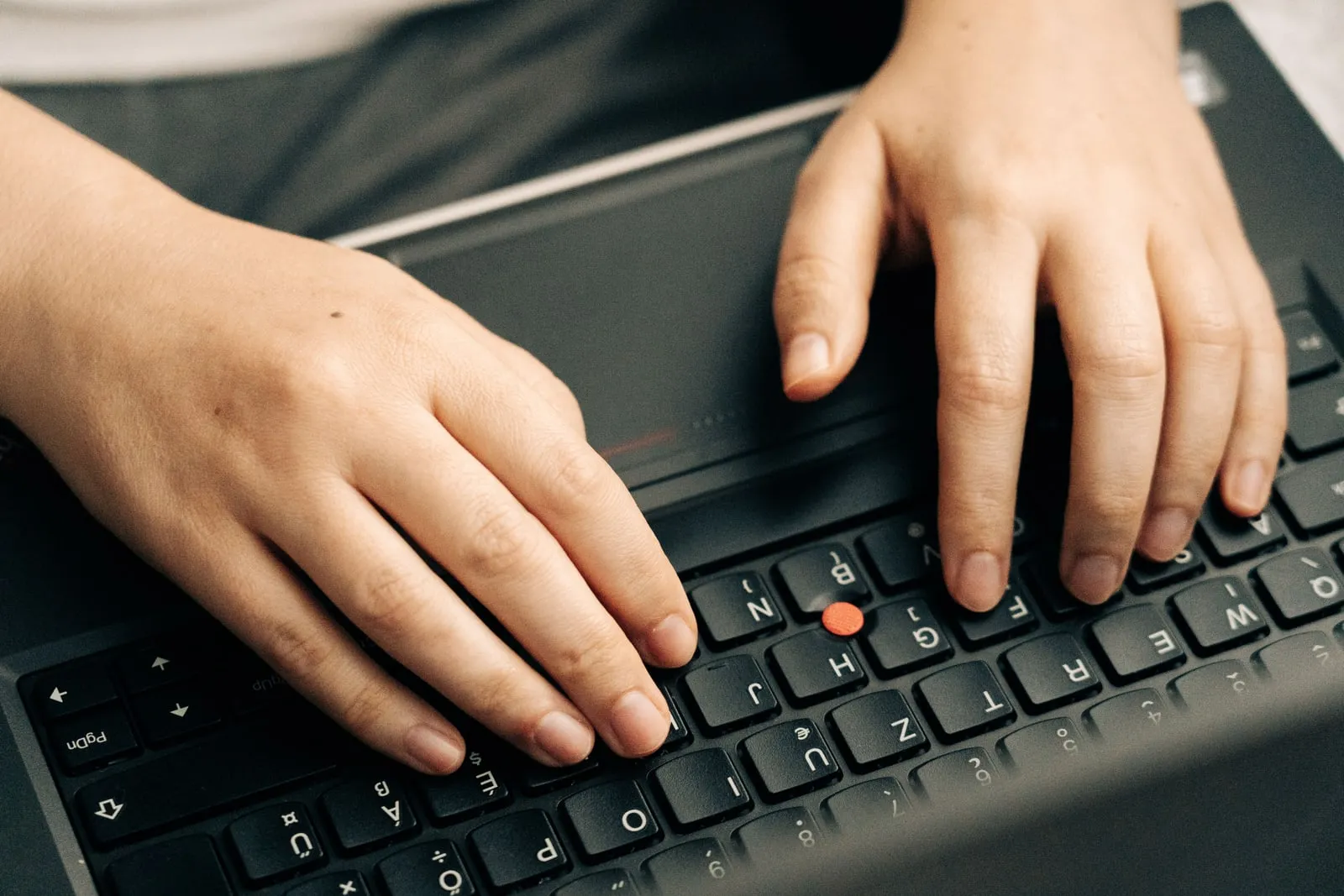 A person typing on a laptop keyboard