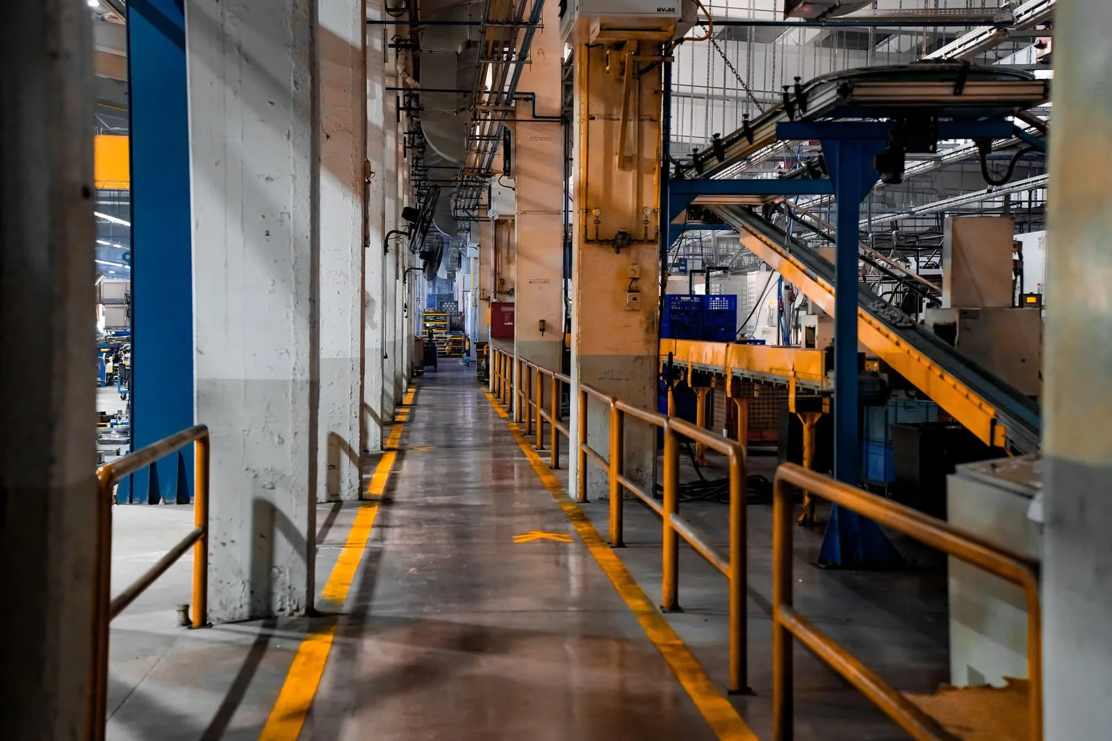 A marked walkway running between machinery inside a factory