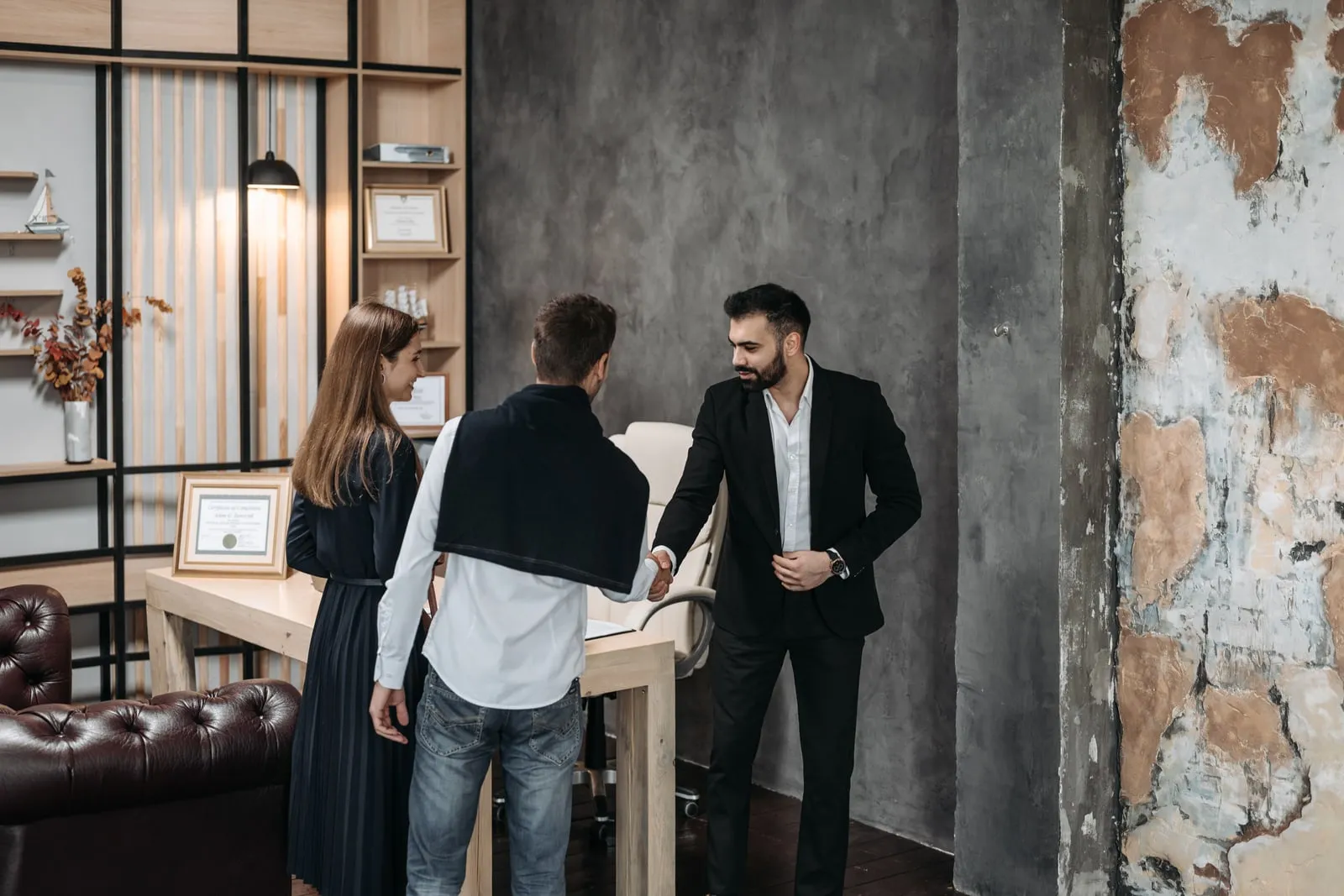 A salesperson shaking hands with a client in an office
