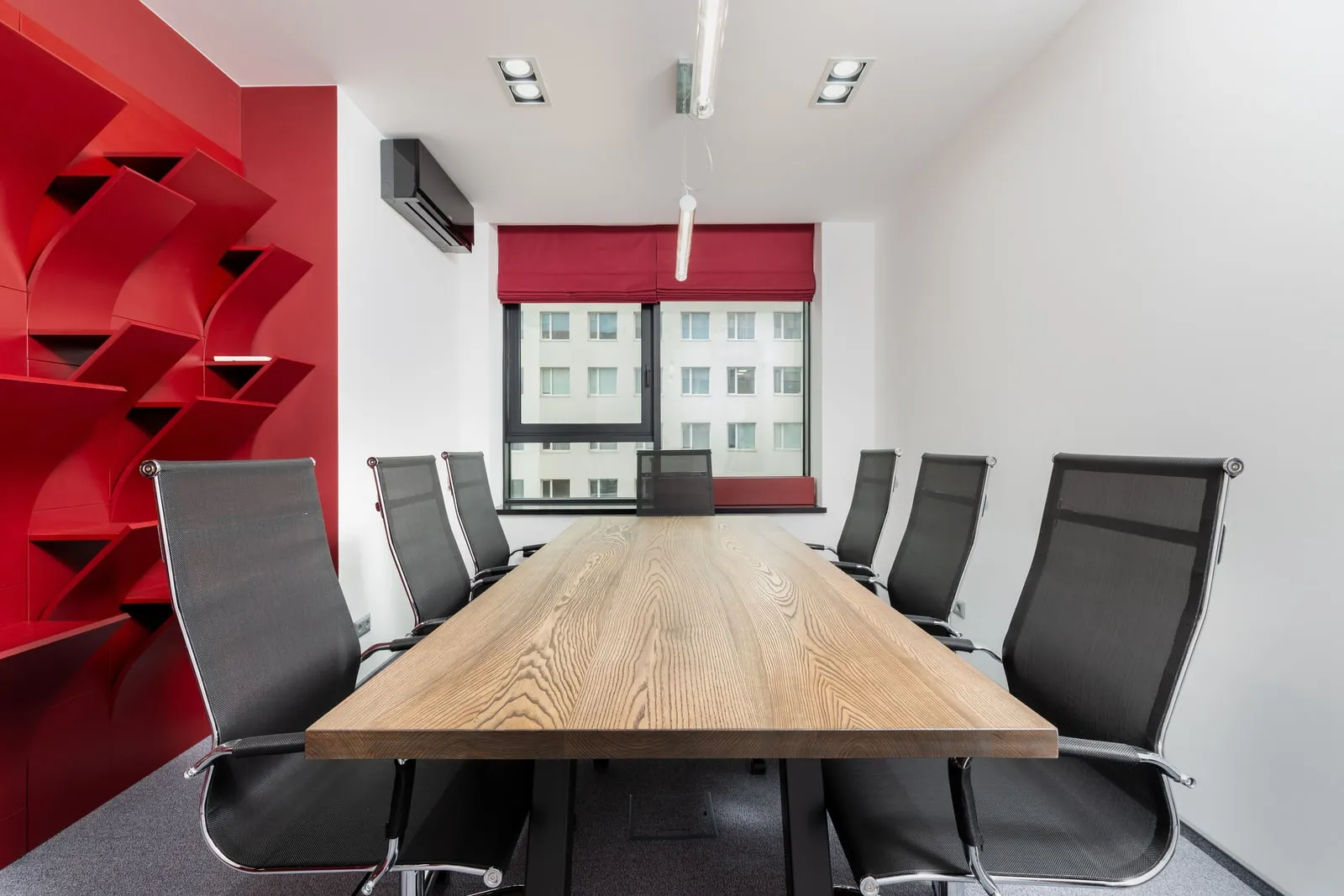 An empty conference room with a long table and chairs