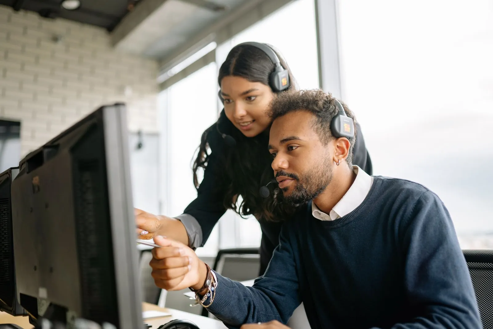 Two colleagues looking together at a computer screen in an office