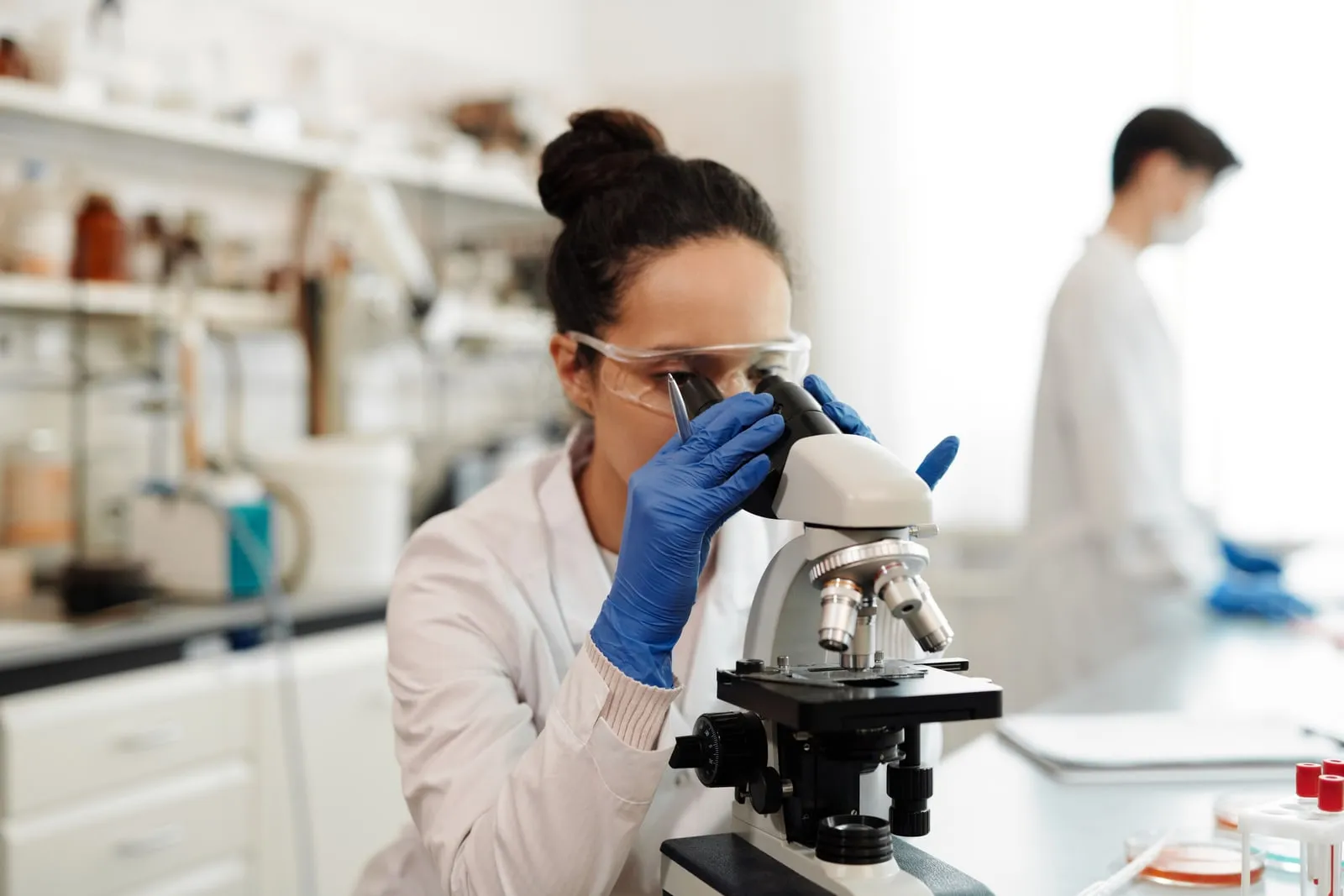 A researcher looking into a microscope in a laboratory