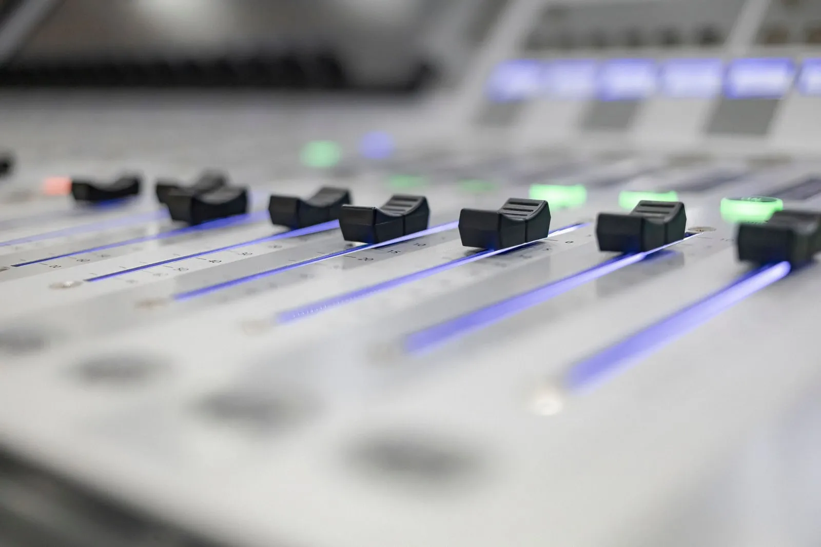 A sound mixing desk with rows of faders