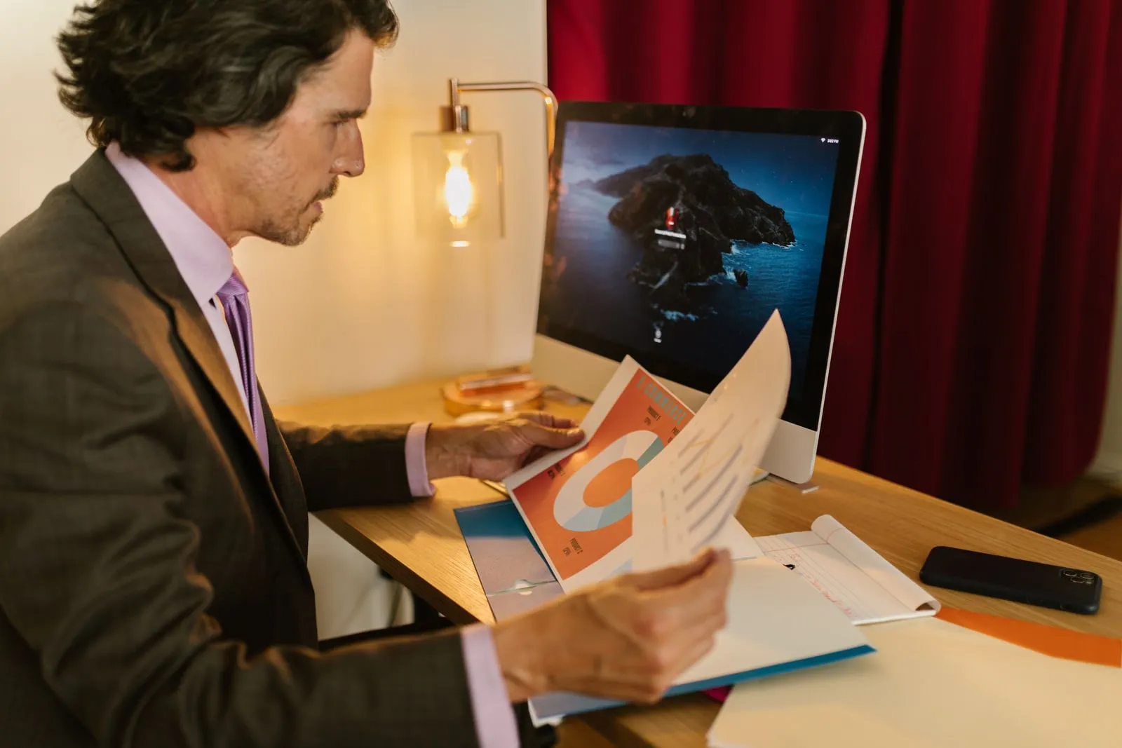 A person reading a printed report at a desk