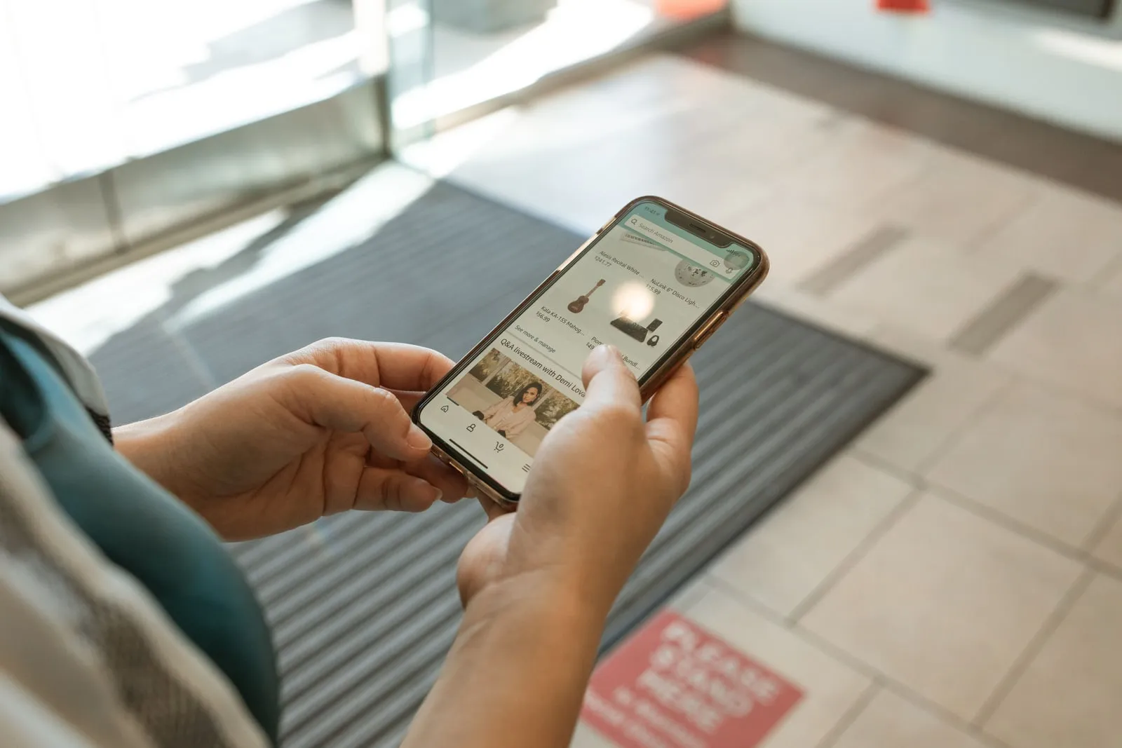 Une personne tenant un smartphone et parcourant une boutique en ligne