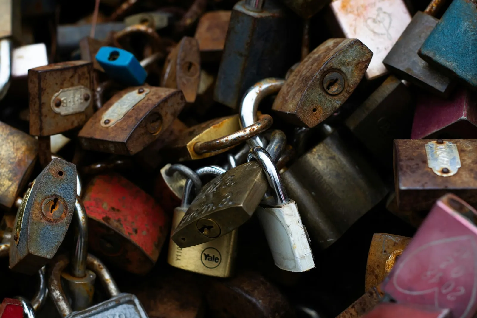 A brass padlock and keys on a wooden desk