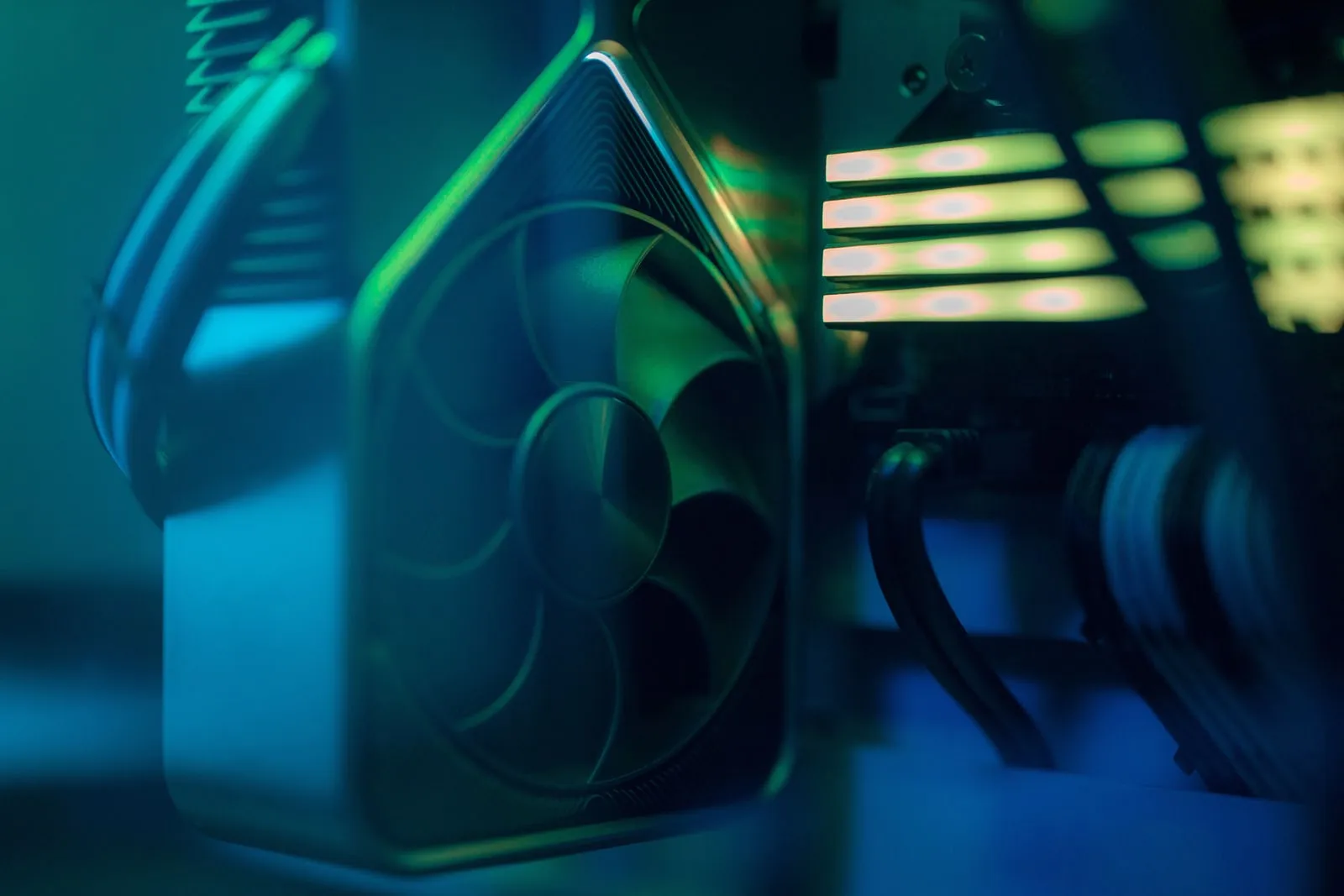 The inside of a desktop PC lit by coloured LEDs, showing a graphics card fan