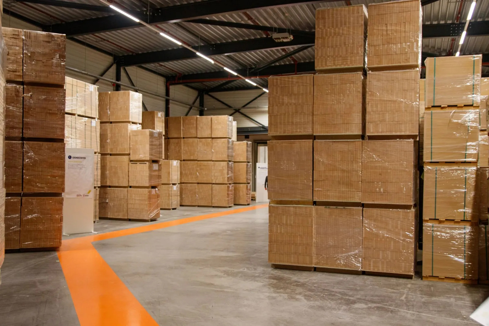 Cardboard boxes stacked along an aisle in a storage warehouse