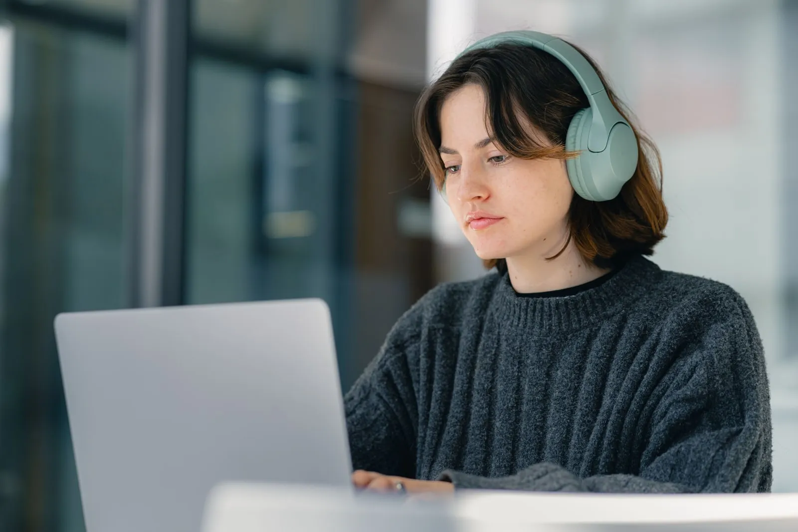 A person wearing headphones at a desk