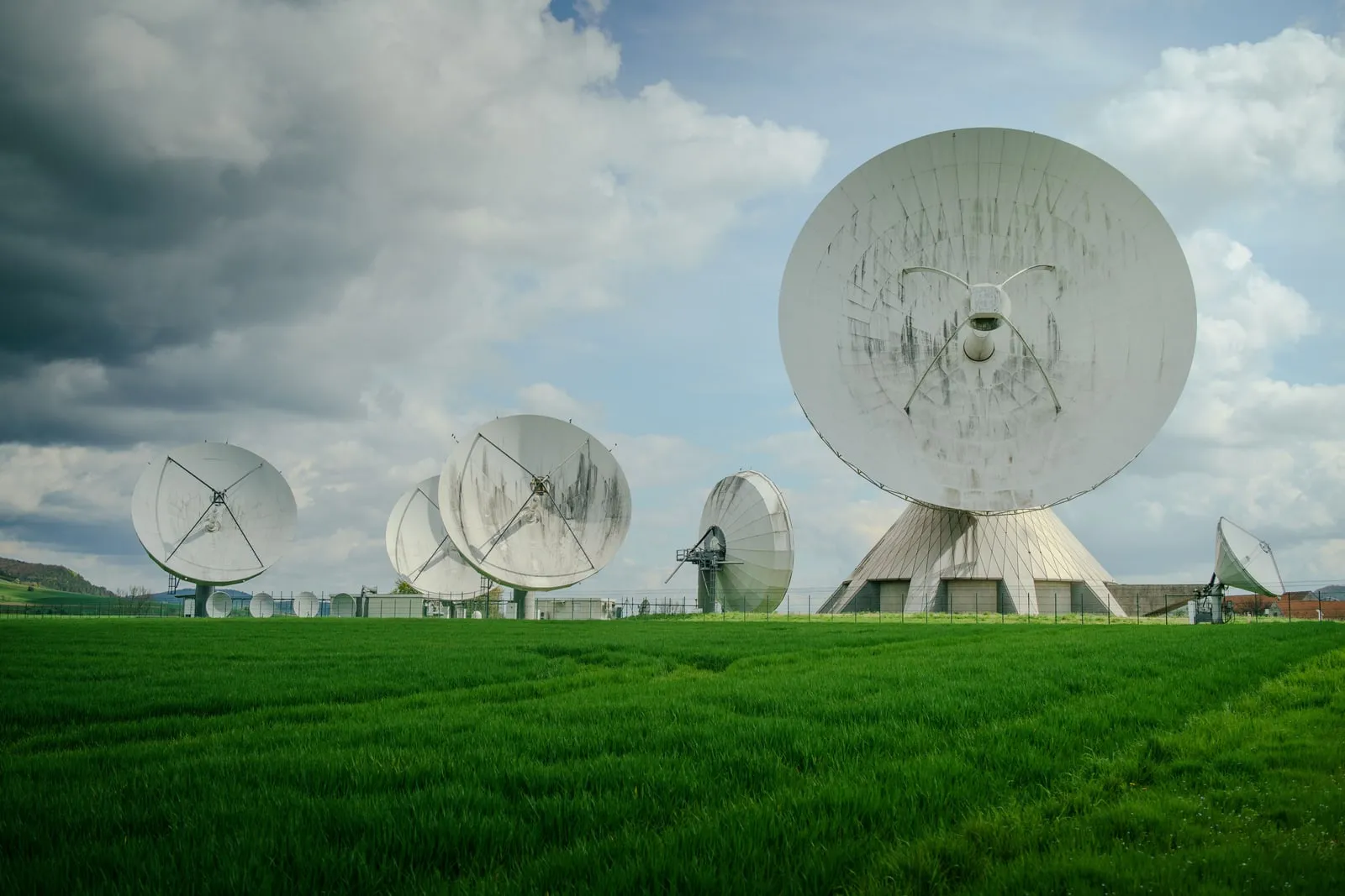 En stor parabolantenne ved en satellitjordstation rettet mod himlen