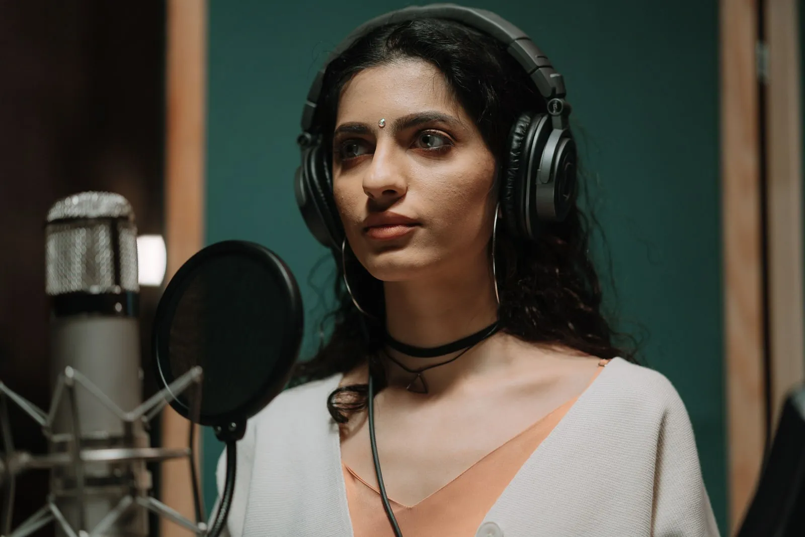 A microphone and headphones in a recording booth