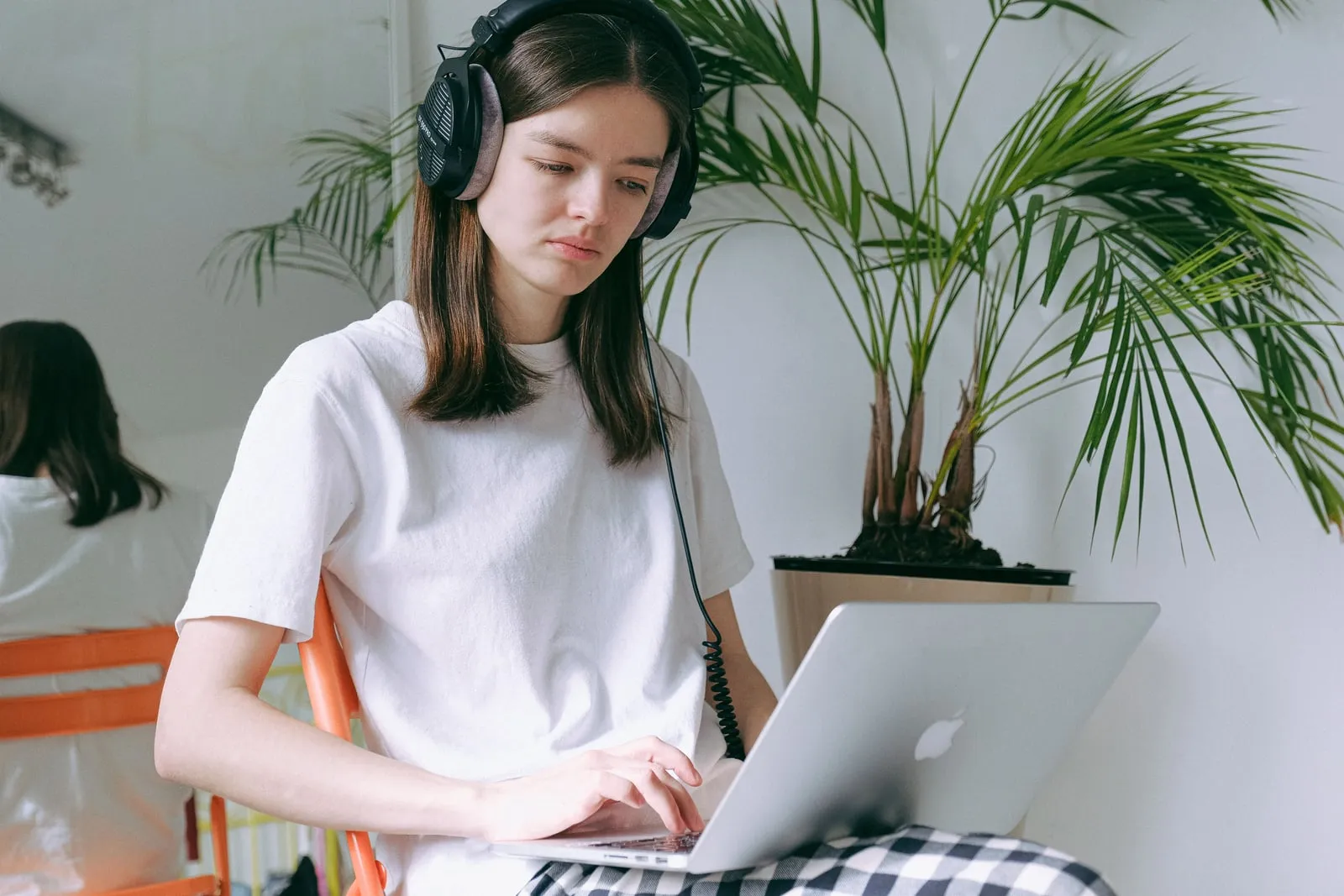 A person wearing headphones at a laptop