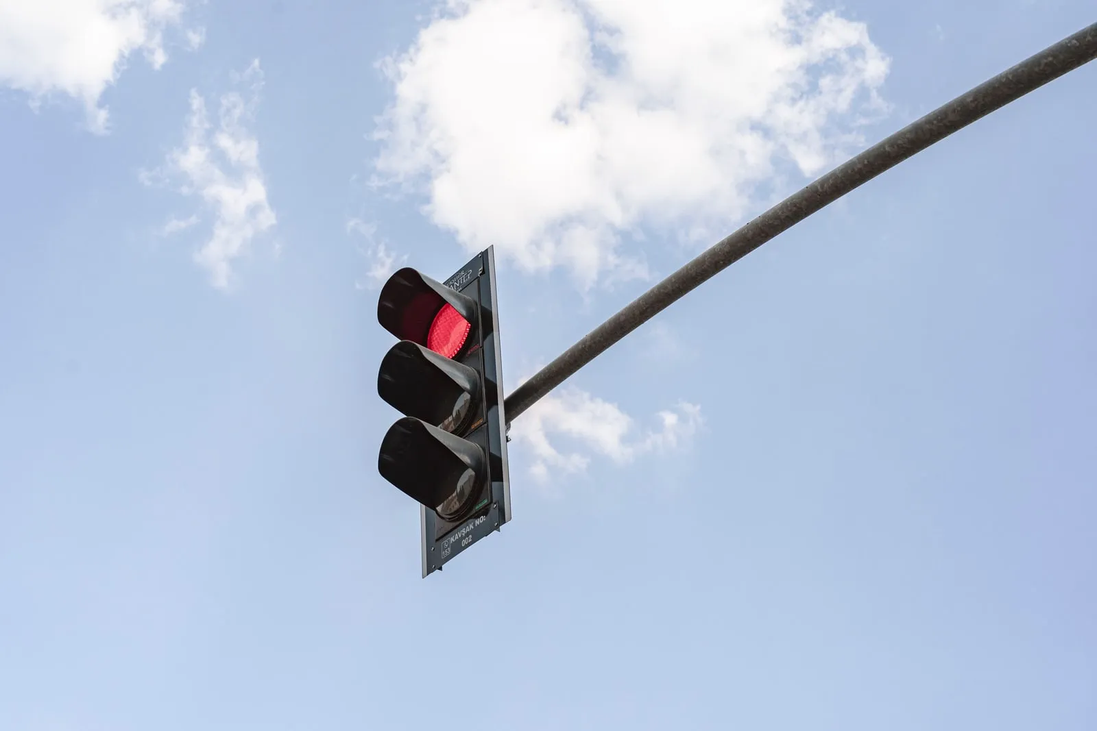 A red traffic light against a blue sky