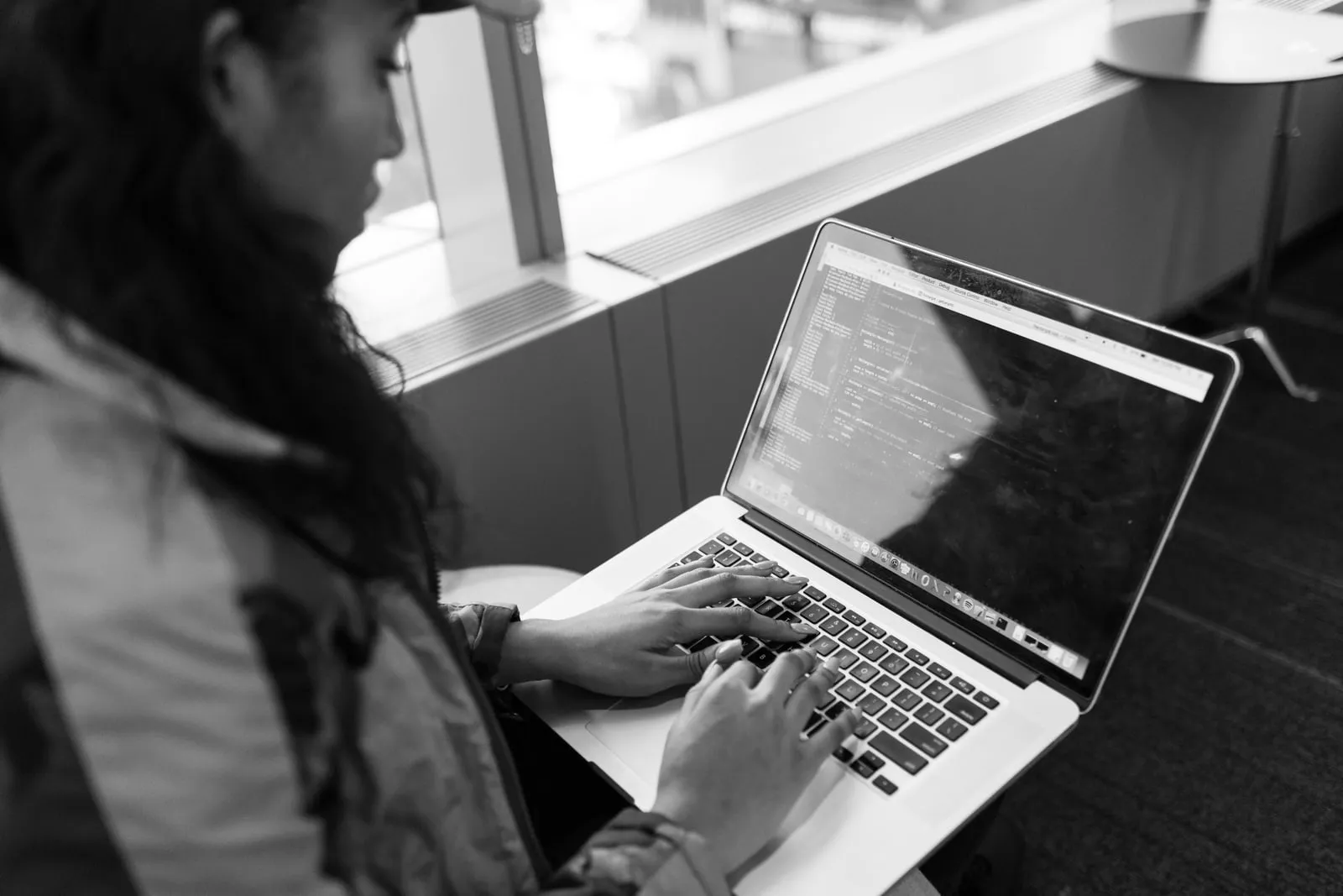 A developer reviewing code on a laptop screen.