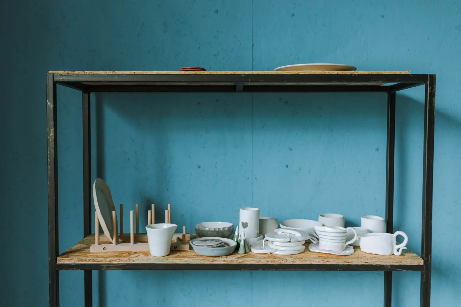 Assorted white ceramic pieces on a studio shelf